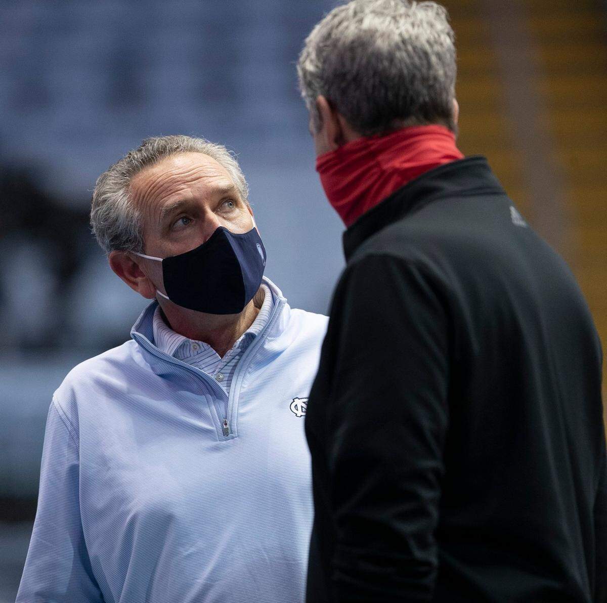 North Carolina athletic director Bubba Cunningham talks with N.C. State athletic director Boo Corrigan during halftime on Saturday, January 23, 2021 at the Smith Center in Chapel Hill, NC.