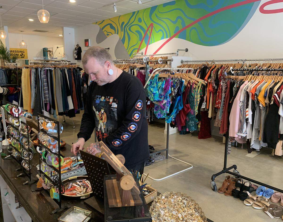 Micah Moses rearranges necklaces in the Durham Rumors location.