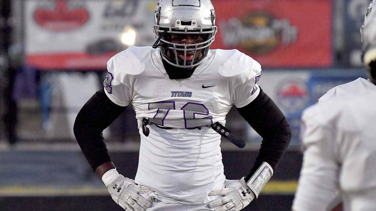 South Garner lineman Ekene Ogboko rests in between pre-game drills before their game against Willow Spring. The Willow Spring Storm and the South Garner Titans met in a football game in Fuquay-Varina. N.C. on October 18, 2024.