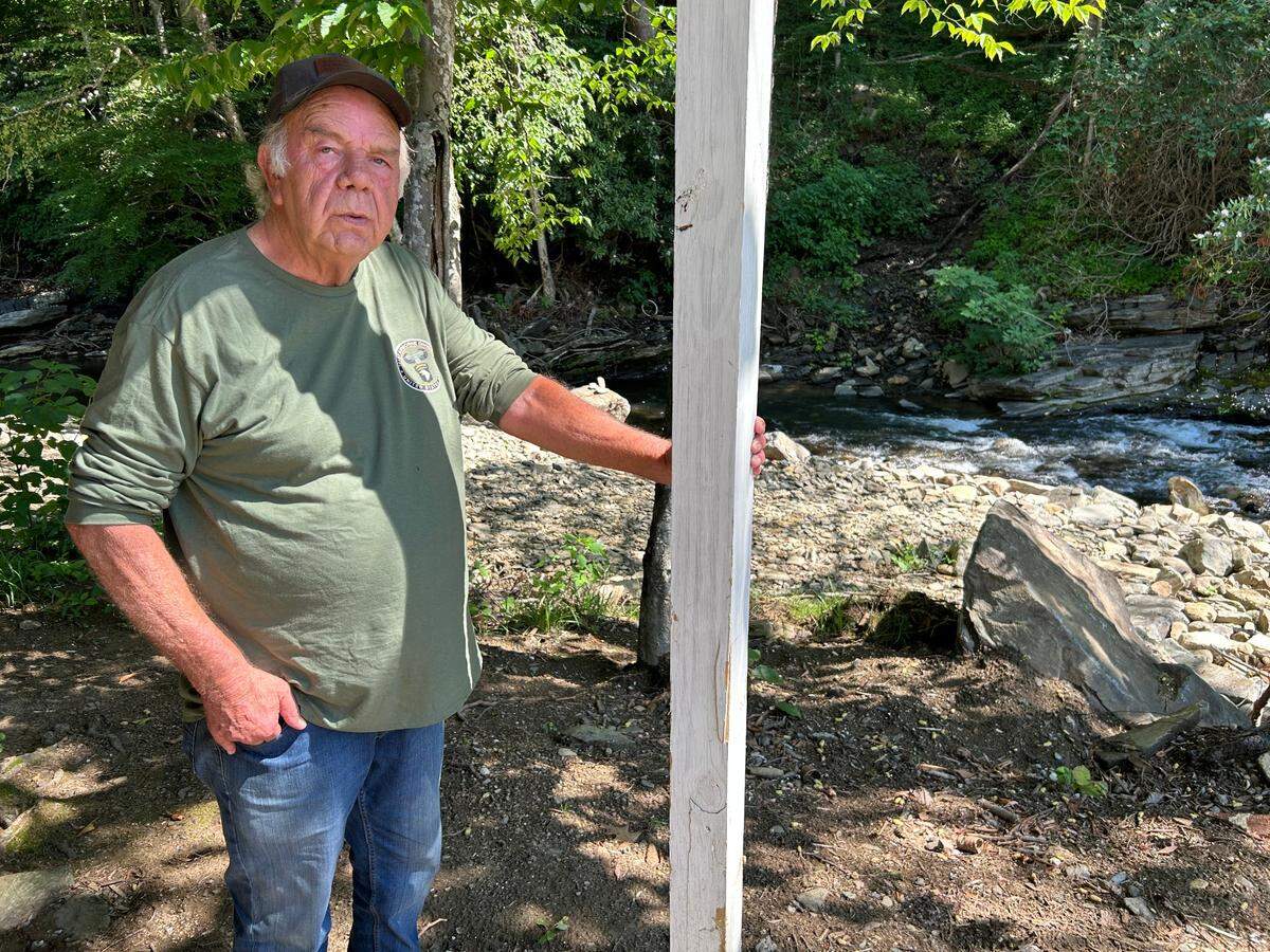 Bob Tatum stands by the North Toe River that destroyed his house, now only a trickle since Hurricane Helene has passed.