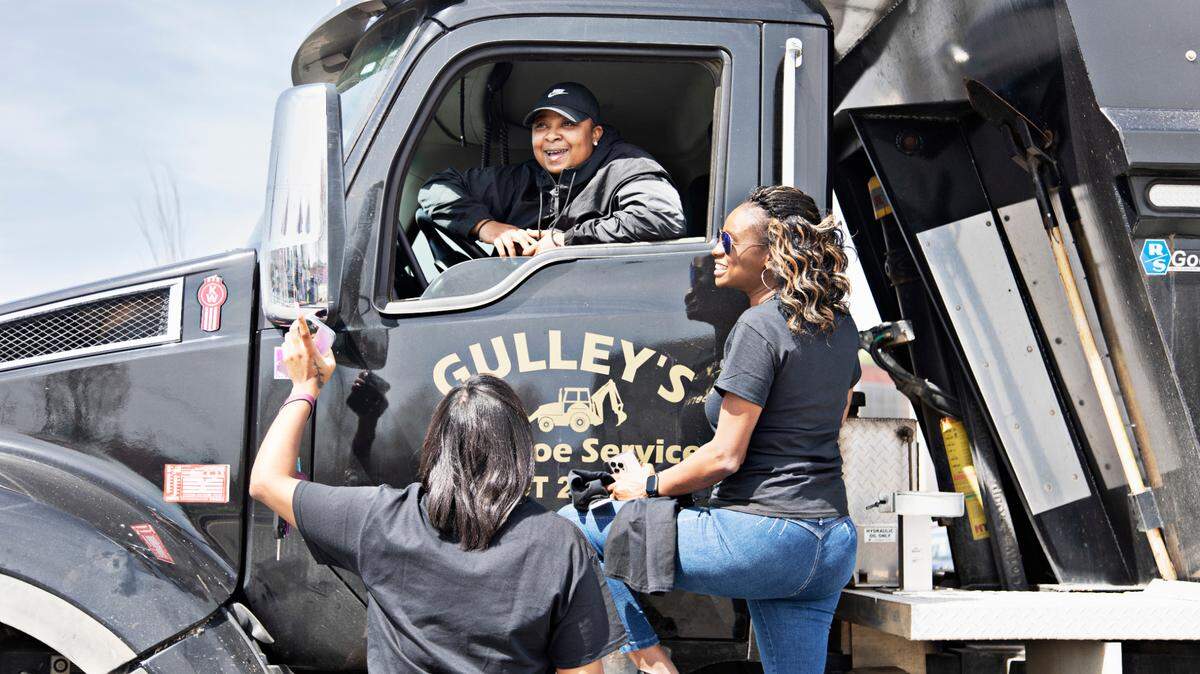 Candice Gulley Hines, right, talks with driver, Lakeisha Boone, center, and Tnea Taylor, left, who all work for her family’s business, Gulley’s Backhoe Service, at a job site in Raleigh on Tuesday, March 22, 2022. Gulley Hines’ parents started the business in 1984 so she has grown up in the business and raised her daughter, Tnea Taylor, to work there as well.