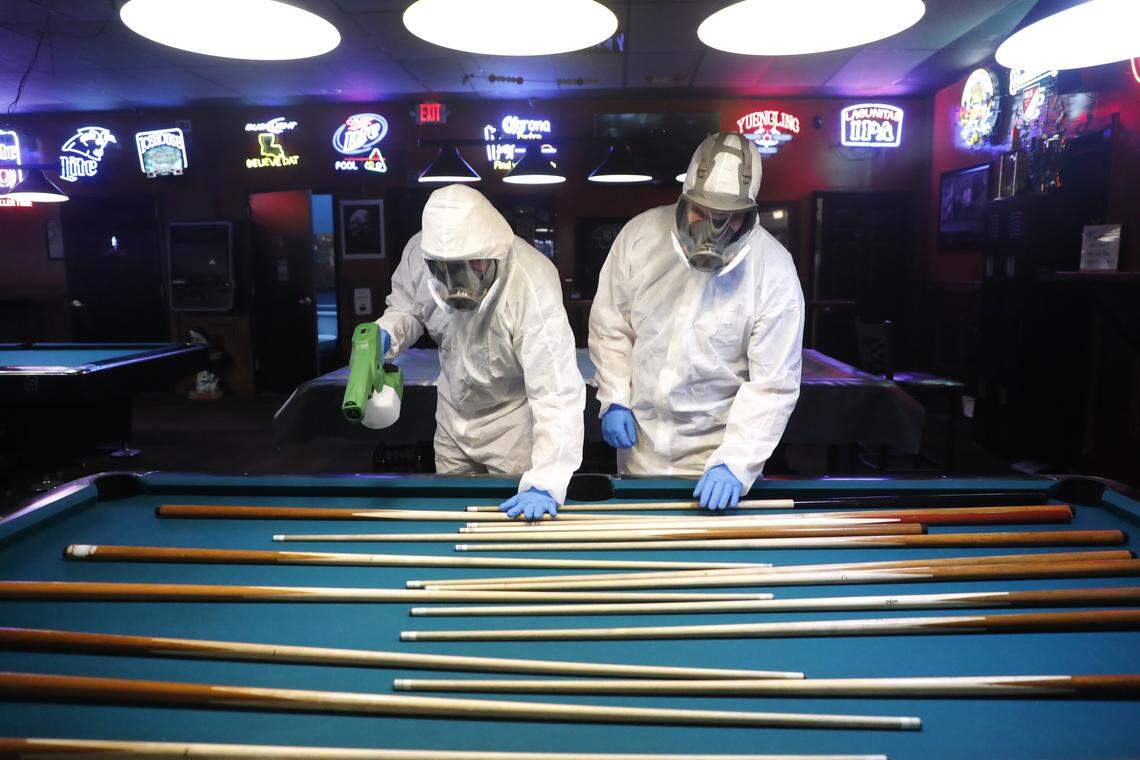 Tyler Page, left, and Chris Wedlock, technicians with 6 & Fix, Inc., help disinfect and protect Sharky’s Place in Raleigh, N.C., Friday morning May 22, 2020. The technicians apply a hospital level disinfectant and then apply a barrier spray that protects the surfaces for 90 days. Sharky’s will open at 5 p.m.