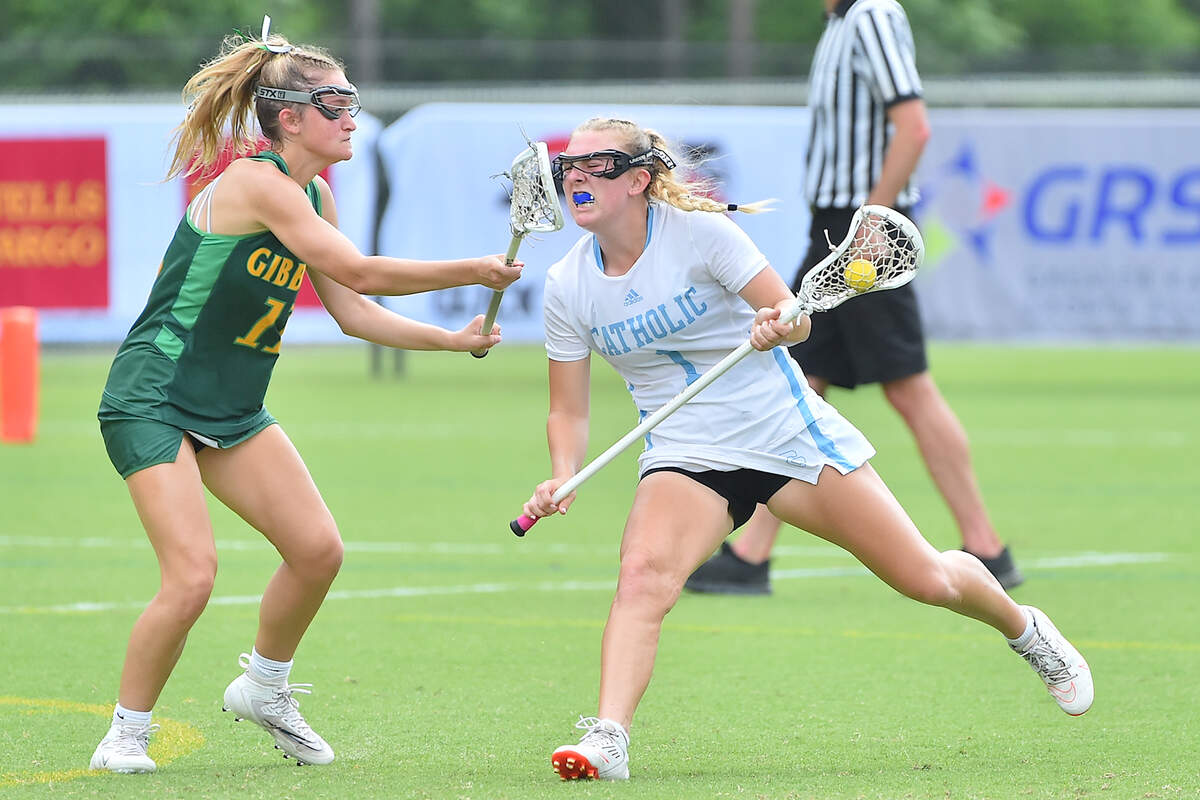 Charlotte Catholic’s Barbara Tucker (1) moves across the field and defended by Cardinal Gibbons’ Emma Carmouche (11) during the first half. The Cardinal Gibbons Crusaders and the Charlotte Catholic Cougars met in the NCHSAA Women’s Lacrosse Championships in Cary, N.C. on May 21, 2022.