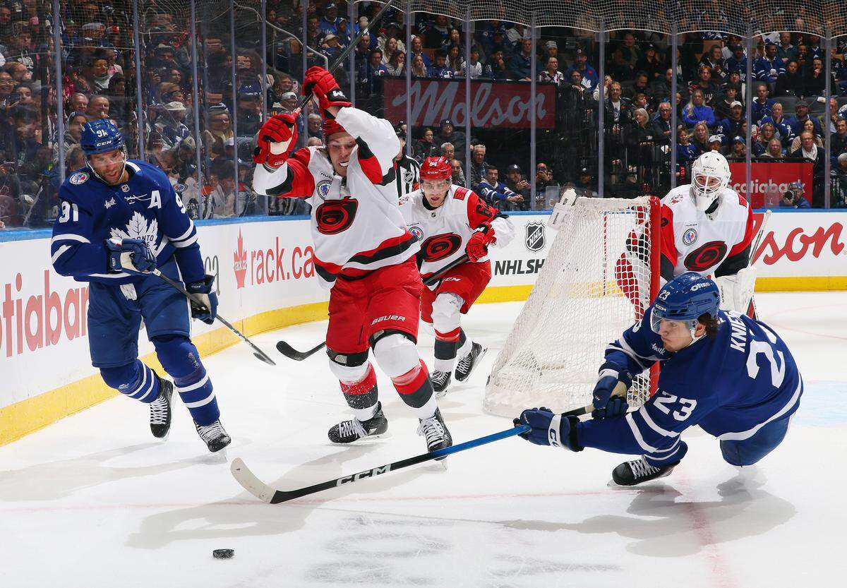 Alexander Nikishin (21) of the Carolina Hurricanes defends against John Tavares, left, and Matthew Knies of the Toronto Maple Leafs during the second period at Scotiabank Arena on Nov. 9, 2025 in Toronto, Ontario, Canada.