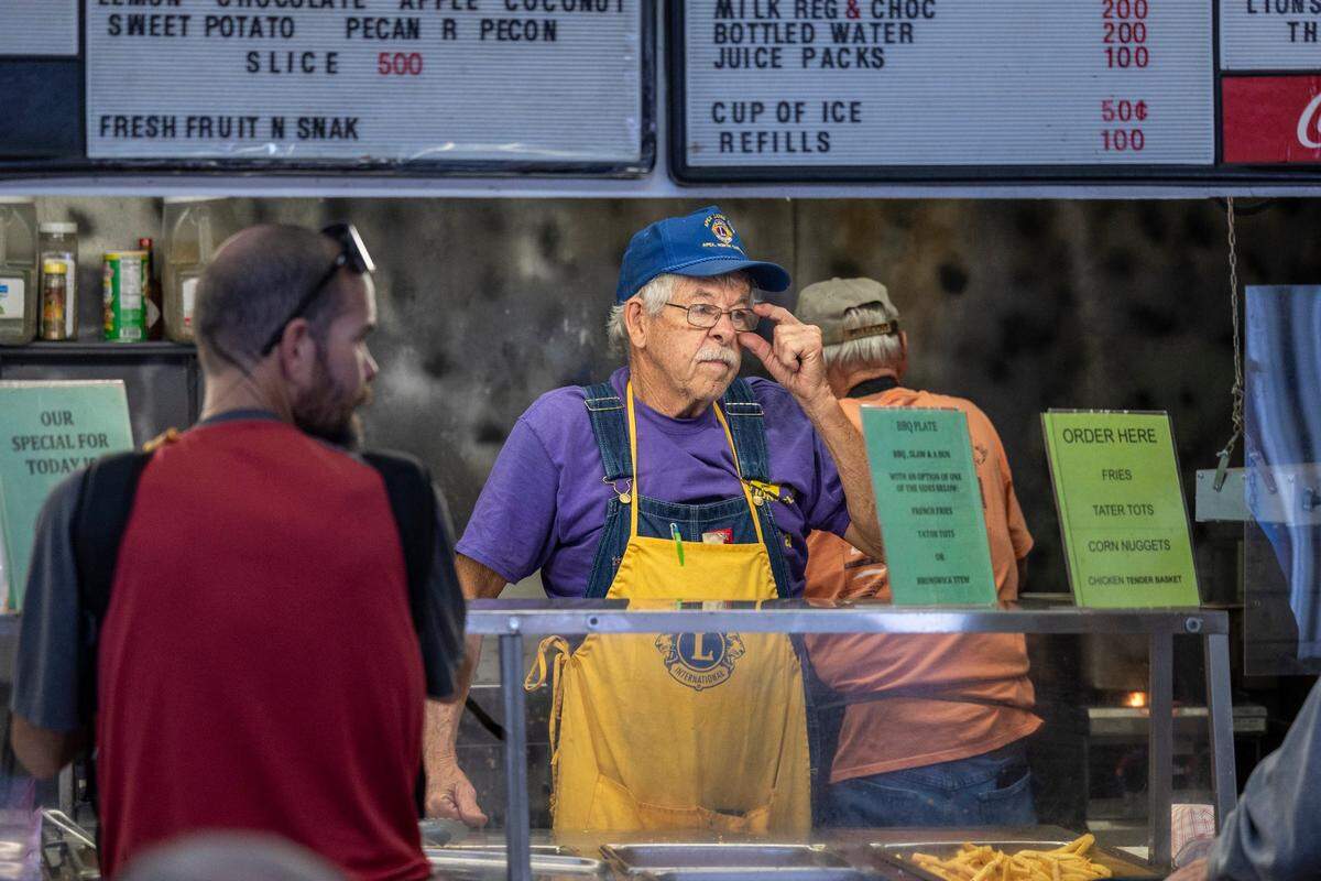 Longtime manager Horace Johnson, center, takes food orders at the Apex Lions Club restaurant during the State Fair in Raleigh Monday, Oct. 16, 2023. The Apex Lions Club has been serving food at the fair’s restaurant row since 1943. The restaurant row building will be replaced with an events center next year.
