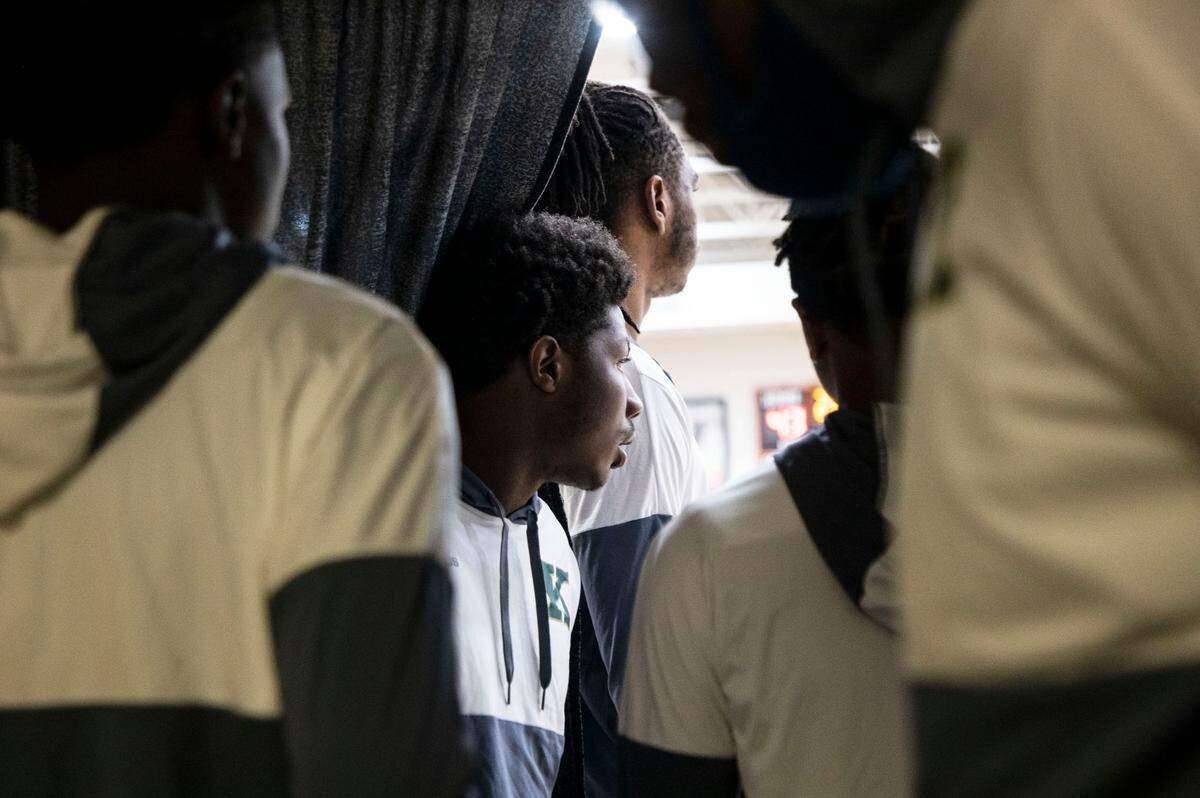 Kinston High School varsity basketball players look out onto the court at Southwest Onslow High School before their game in Jacksonville, N.C. on Jan. 5, 2022.
