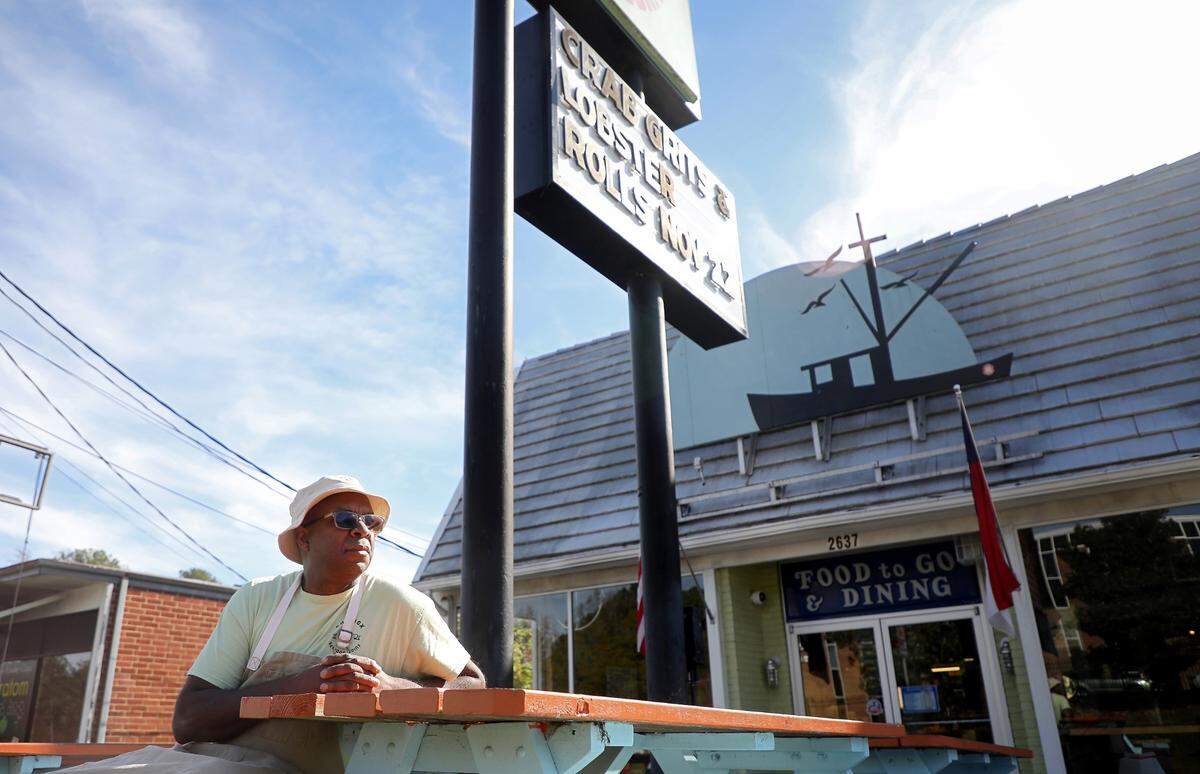 Ricky Moore, the chef and owner of Saltbox Seafood Joint, sits in the restaurant’s outdoor dining area in 2022. Moore, already a James Beard winner, is a 2025 semifinalist for Outstanding Chef in the country.