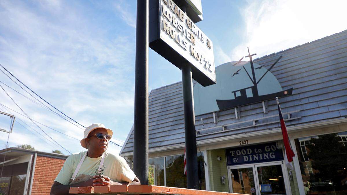 Ricky Moore, the chef and owner of Saltbox Seafood Joint, sits in the restaurant’s outdoor dining area in 2022. 