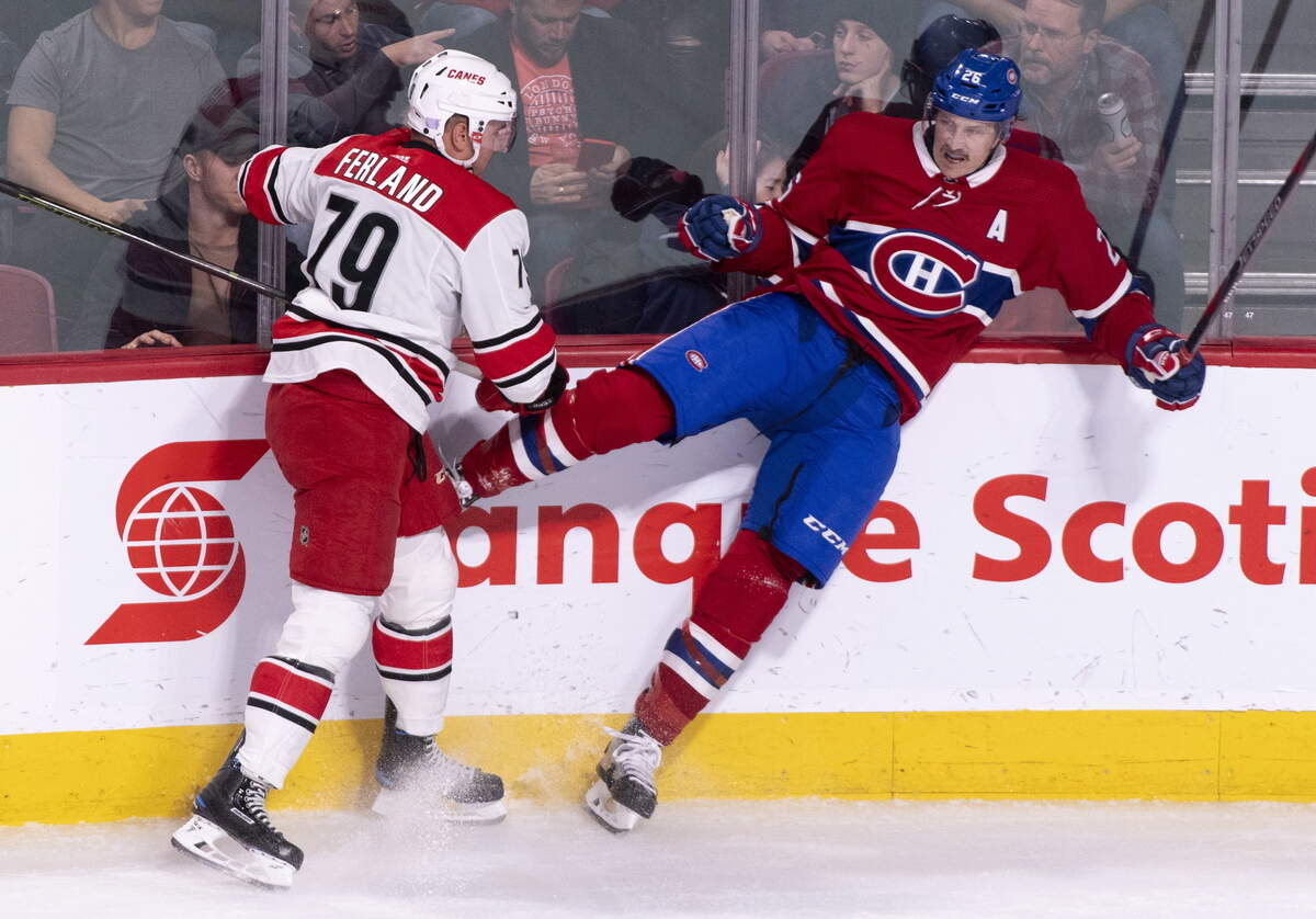 Montreal Canadiens’ Jeff Petry takes a hit from Carolina Hurricanes’ Micheal Ferland during the first period of an NHL hockey game Tuesday, Nov. 27, 2018, in Montreal.