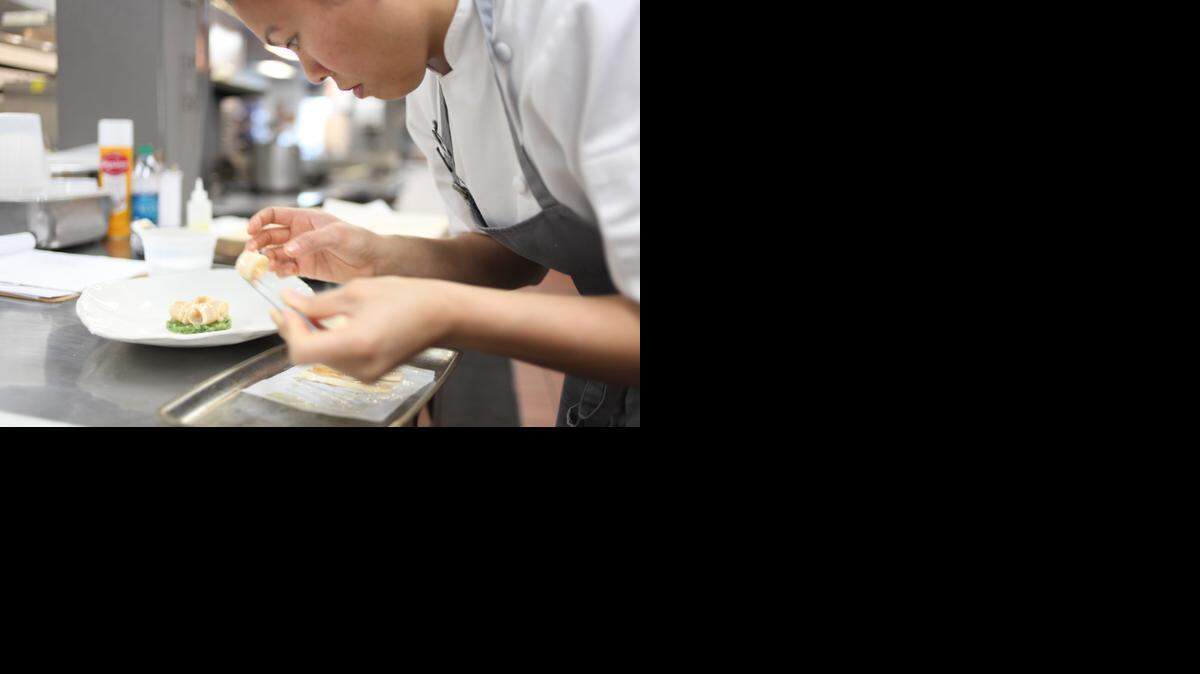 One co-chef Kim Floresca carefully constructs a dish in the restaurant’s kitchen in Chapel Hill earlier this year. Floresca and her husband and co-chef, Daniel Ryan, took over the restaurant in Chapel Hill last summer.
