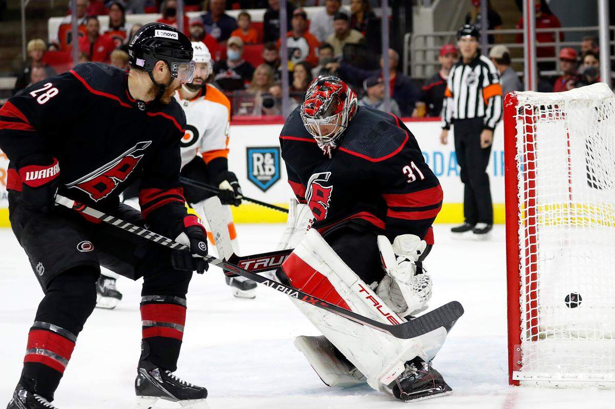 Carolina Hurricanes’ Ian Cole (28) watches as a shot from Philadelphia Flyers’ Zack MacEwen, not seen, slips past goaltender Frederik Andersen (31) during the third period of an NHL hockey game in Raleigh, N.C., Friday, Nov. 12, 2021. (AP Photo/Karl B DeBlaker)