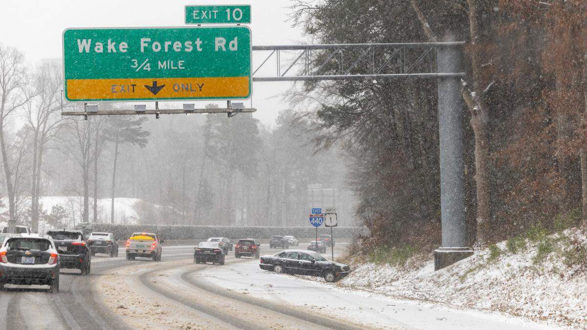 A disabled vehicle rests near the Wake Forest Road exit on the I-440 Beltline in Raleigh as snow begins to accumulate Wednesday, Feb. 19, 2024.