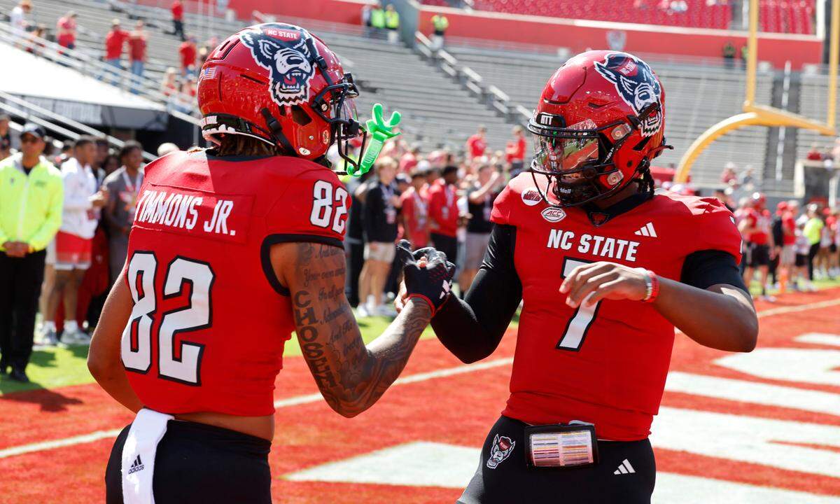N.C. State wide receiver Terrell Timmons Jr. (82) greets quarterback MJ Morris (7) during warmups before N.C. State’s game against Marshall at Carter-Finley Stadium in Raleigh, N.C., Saturday, Oct. 7, 2023.