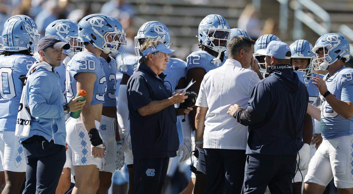 North Carolina head coach Bill Belichick huddles with the team during a timeout in the second half of Clemson’s 38-10 victory over UNC at Kenan Stadium in Chapel Hill, N.C., Sat. Oct. 4, 2025.