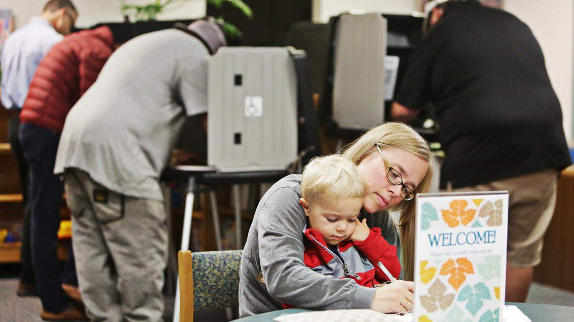 Sarah Turinsky, right, holds her son, Barron, 3, in her lap as she votes early Tuesday morning Nov. 6, 2018, at Project Enlightenment in Raleigh.