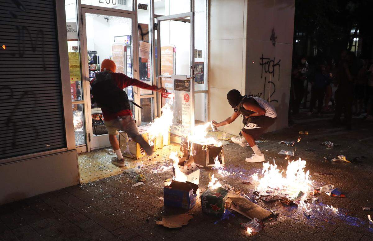Protesters burn items in front of the CVS Pharmacy in downtown Raleigh, N.C. Saturday, May 30, 2020.