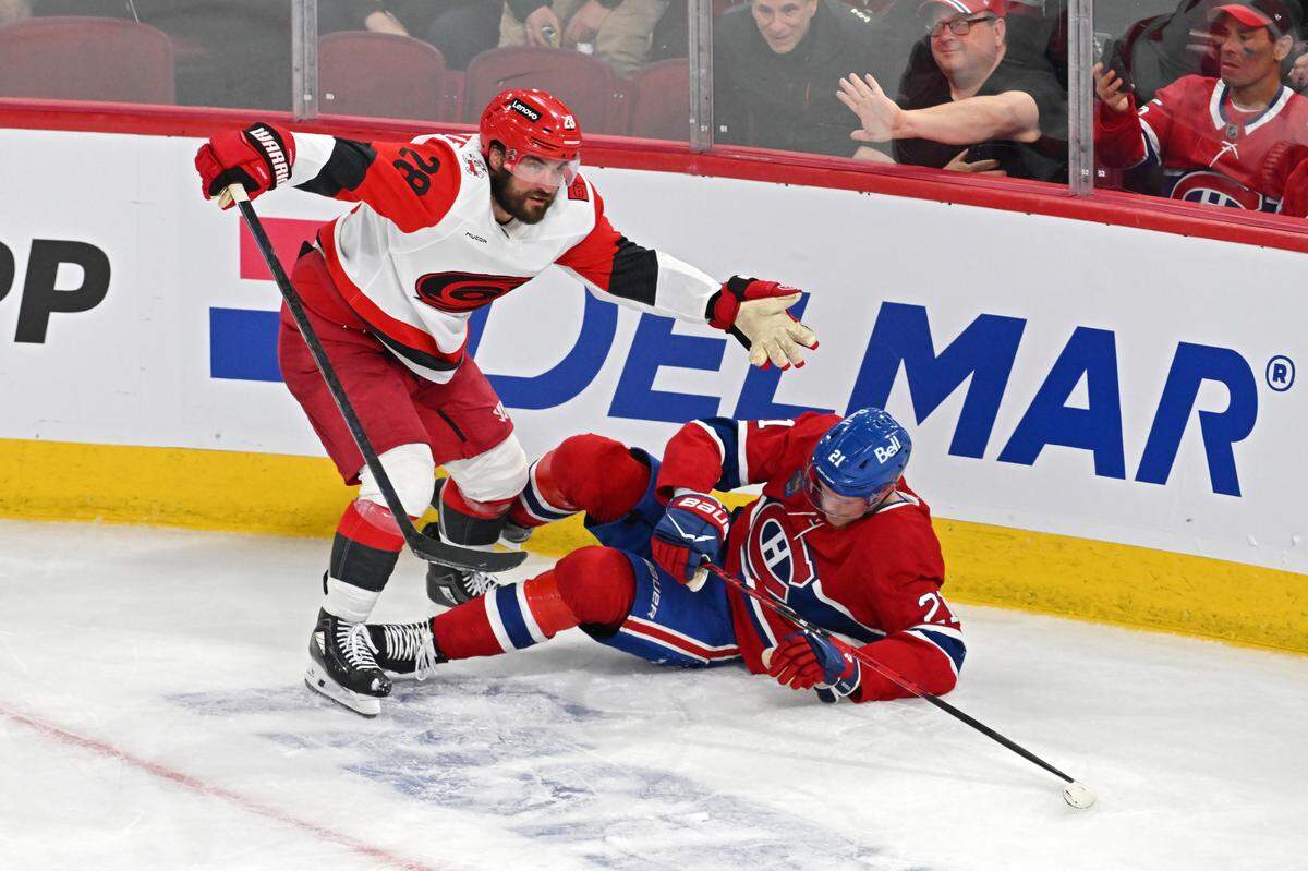 William Carrier #28 of the Carolina Hurricanes knocks down Kaiden Guhle #21 of the Montreal Canadiens during the third period in Game Four of the Eastern Conference Final of the 2026 Stanley Cup Playoffs at Bell Centre on May 27, 2026 in Montreal, Quebec, Canada. 