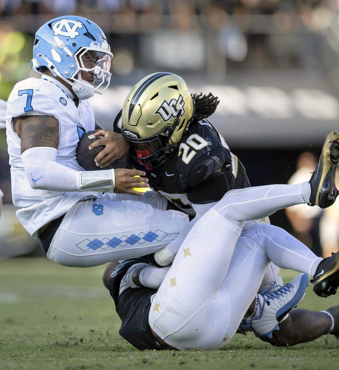 North Carolina quarterback Gio Lopez (7) stopped after a three-yard gain by UCF safety Phillip Dunnam (2)  and linebacker Lewis Carter (20) in the third quarter on Saturday, September 20, 2025 in Orlando, Fla.