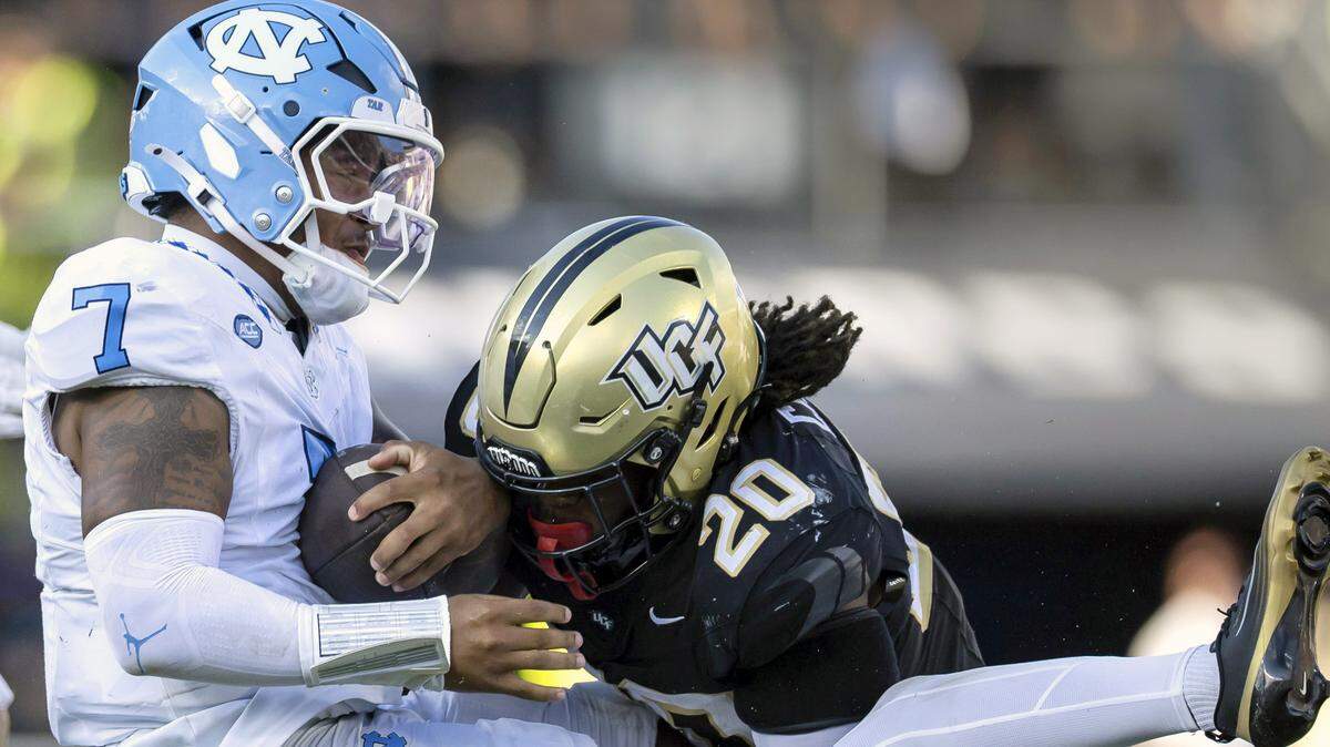 North Carolina quarterback Gio Lopez (7) stopped after a three-yard gain by UCF safety Phillip Dunnam (2) and linebacker Lewis Carter (20) in the third quarter on Saturday, Sept. 20, 2025 in Orlando, Fla.