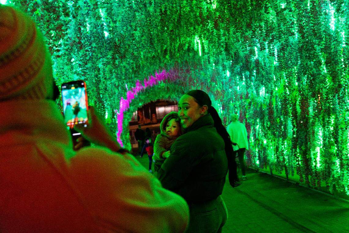 Deiara Frye, right, poses for a photo with her four-month-old, Samaiha Frye, as they visit the Chinese Lantern Festival at Koka Booth Amphitheatre in Cary on Wednesday evening, Dec. 22, 2021. Fryes mom, Shamina Williams, takes the photo as the three visit the Festival for the first time.
