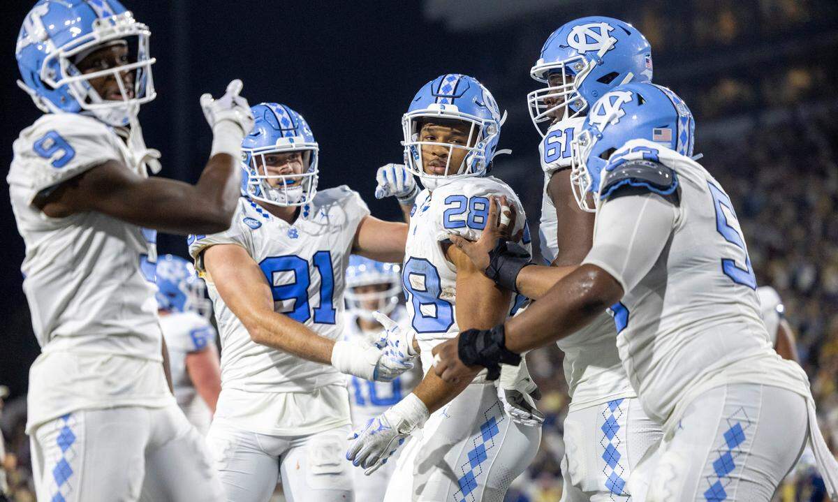 North Carolina’s Omarion Hampton (28) is surrounded by teammates after scoring on a three-yard run to give the Tar Heels’ a 28-21 lead in the second quarter on Saturday, October 28, 2023 at Bobby Dodd Stadium in Atlanta, Georgia.
