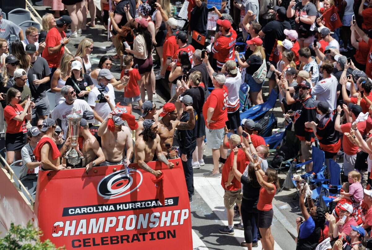 Carolina Hurricanes players and families wave to fans from a parade route celebrating their Stanley Cup Championship on Saturday, June 20, 2026, in Raleigh, N.C.