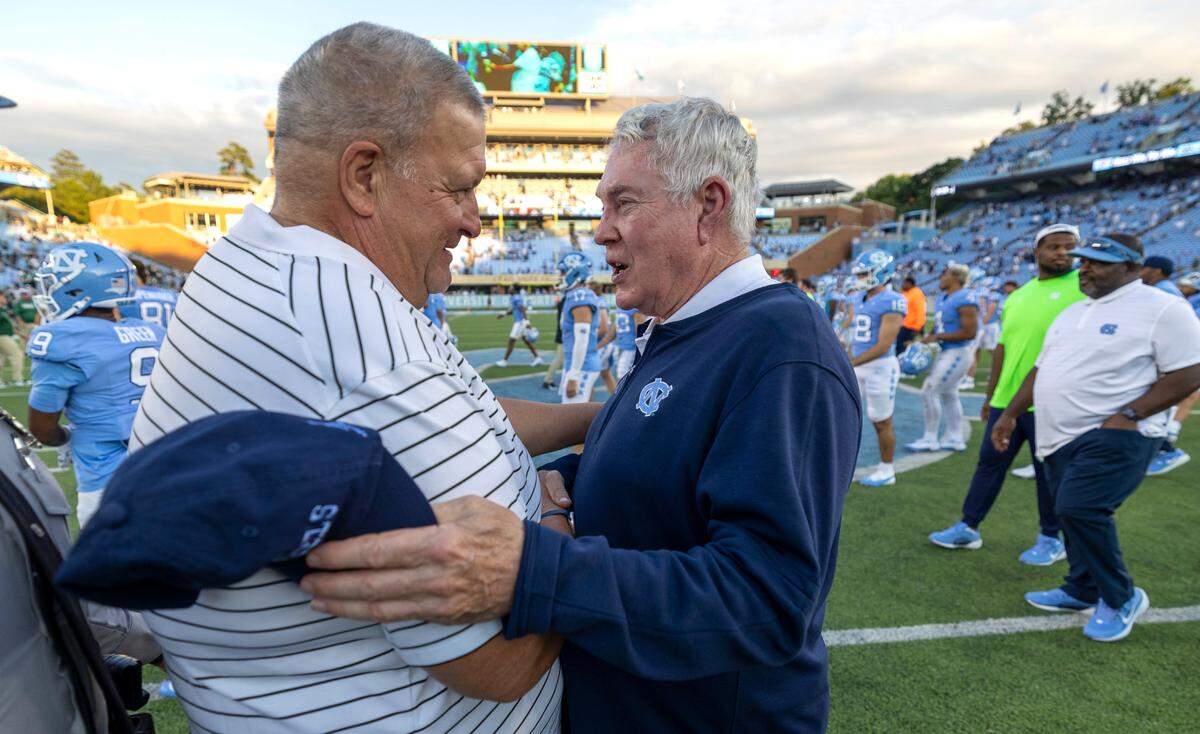 Charlotte head coach Biff Poggi congratulates North Carolina coach Mack Brown following the Tar Heels’ 38-20 victory on Saturday, September 7, 2024 at Kenan Stadium in Chapel Hill, N.C.