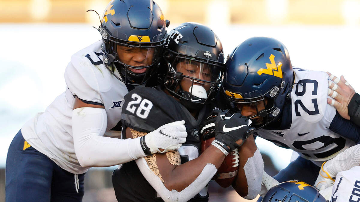 Iowa State running back Breece Hall, center, fights for yards as he is swarmed by West Virginia cornerback Dreshun Miller, left, and safety Sean Mahone, right during a game on Saturday, Dec. 5, 2020, in Ames, Iowa.