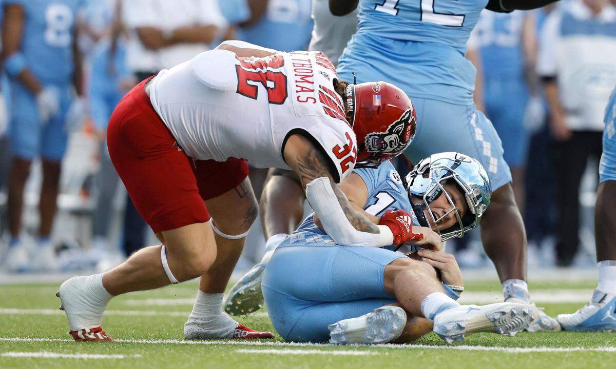 N.C. State linebacker Drake Thomas (32) sacks North Carolina quarterback Drake Maye (10) during the first half of N.C. State’s game against UNC at Kenan Stadium in Chapel Hill, N.C., Friday, Nov. 25, 2022.