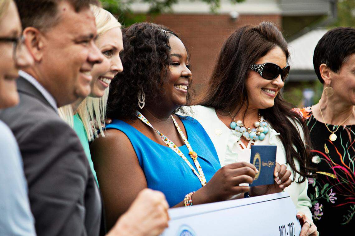 Victoria Lightfoot, center, of MIllbrook Elementary School in Raleigh poses with educators and former award winners on Friday, May 6, 2022, after winning the Milken Educator Award, a prize sometimes called the ‘Oscars of Teaching’ that includes a $25,000 prize.