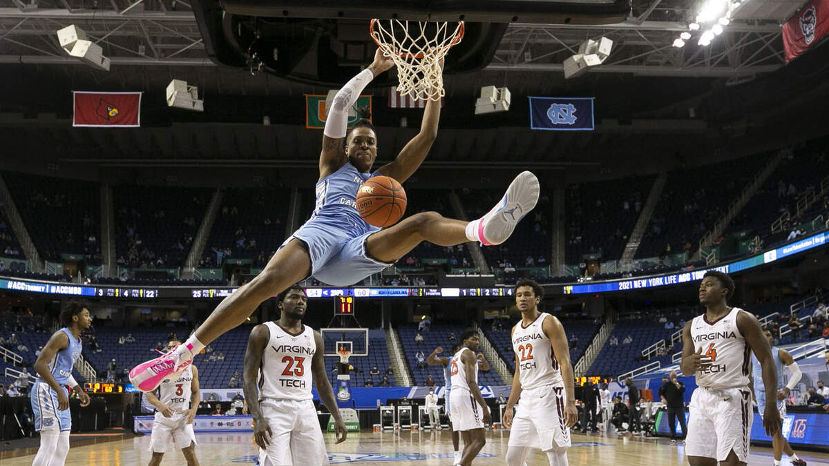 North Carolina’s Armando Bacot (5) gets an acrobatic dunk over the Virginia Tech defense of Tyrece Radford (23), Keve Aluma (22) and Nahiem Alleyne (4) during the second half on Thursday, March 11, 2021 at the ACC Tournament at the Greensboro Coliseum in Greensboro, N.C. Bacot scored 17 points in the Tar Heels; 81-73 victory.