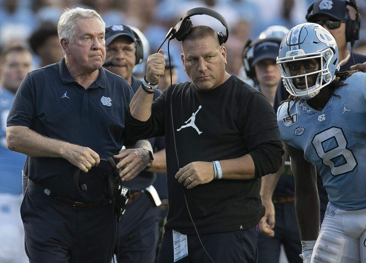 North Carolina offensive coordinator Phil Longo and head coach Mack Brown confer before making the call to go for a two point conversion after scoring a touchdown late in the fourth quarter against Clemson on Saturday, September 28, 2019 at Kenan Stadium in Chapel Hill, N.C.
