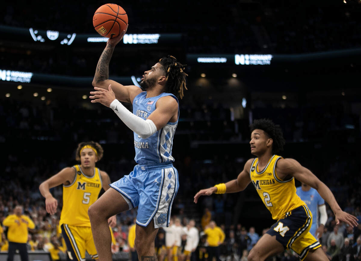 North Carolina’s R.J. Davis (4) beats Michigan’s Terrance Williams II (5) and Kobe Bufkin (2) to the basket during the second half on Wednesday, December 21, 2022 at the Spectrum Center in Charlotte, N.C.