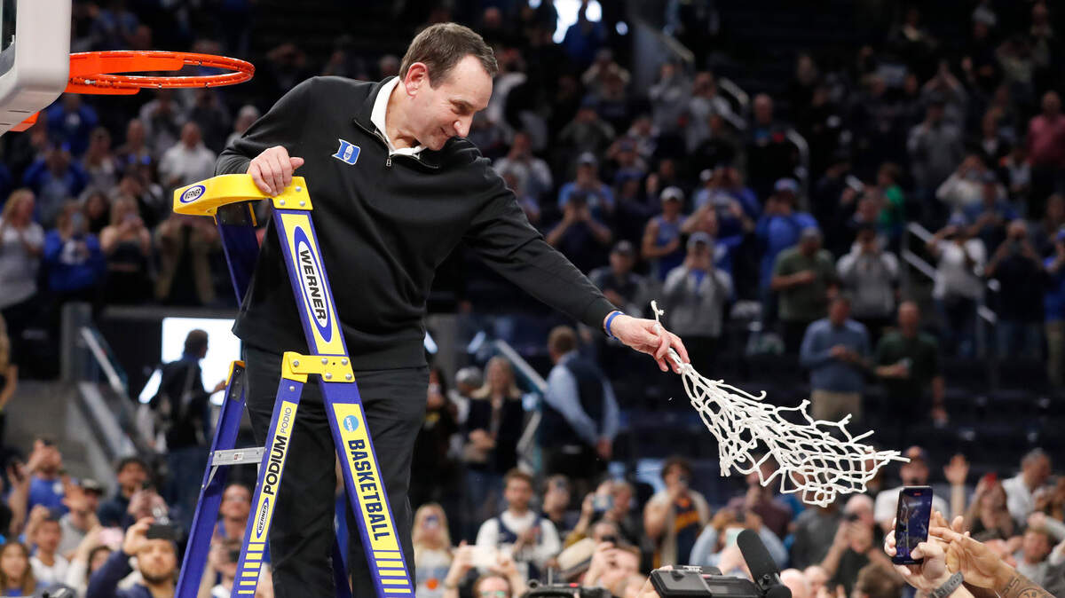 Duke head coach Mike Krzyzewski hands the net to his players after cutting it down after Duke’s 78-69 victory over Arkansas in the NCAA Tournament West Regional finals at the Chase Center in San Francisco, Calif., Saturday, March 26, 2022.