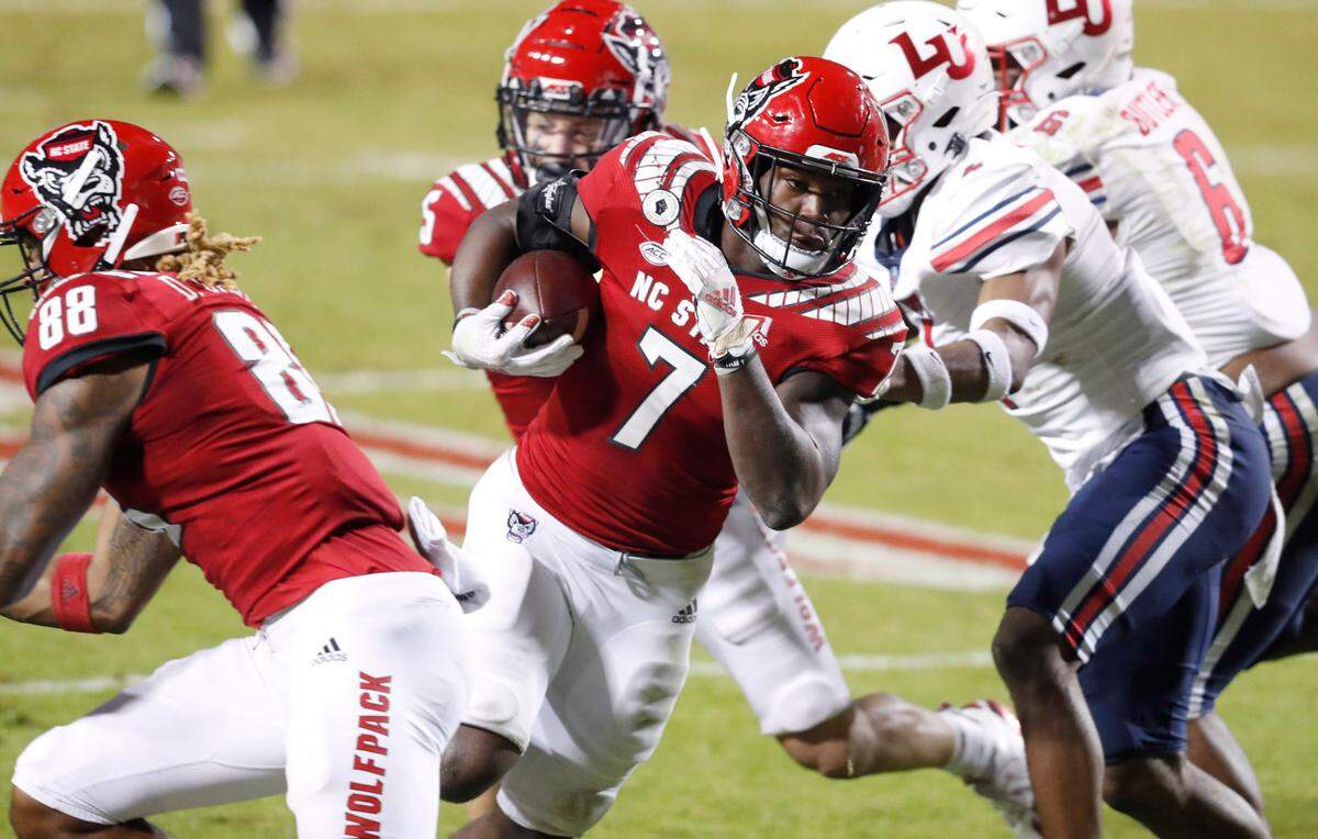 N.C. State running back Zonovan ‘Bam’ Knight (7) avoids Liberty defenders on a 17-yard touchdown run during the Wolfpack’s victory over Liberty at Carter-Finley Stadium in Raleigh, N.C., Saturday, Nov. 21, 2020.