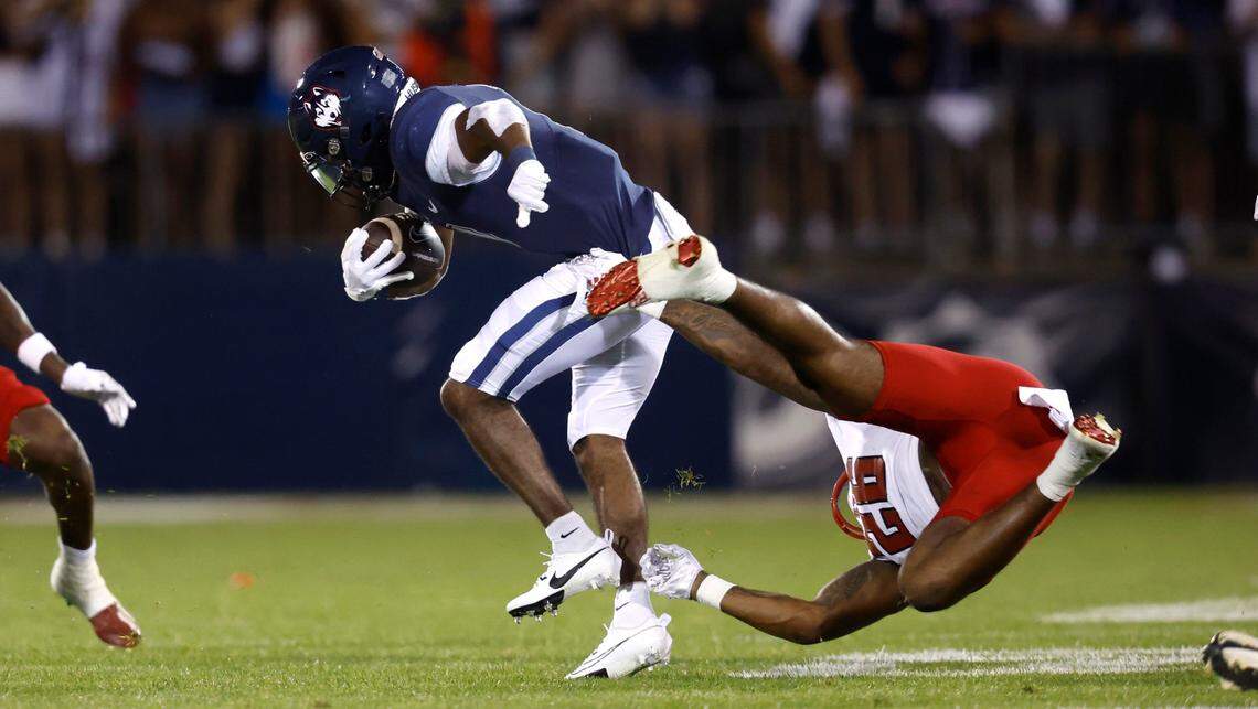 N.C. State linebacker Devon Betty (26) can’t stop Connecticut running back Devontae Houston (1) during the first half of N.C. State’s game against UConn at Rentschler Field in East Hartford, Conn. Thursday, August 31, 2023.