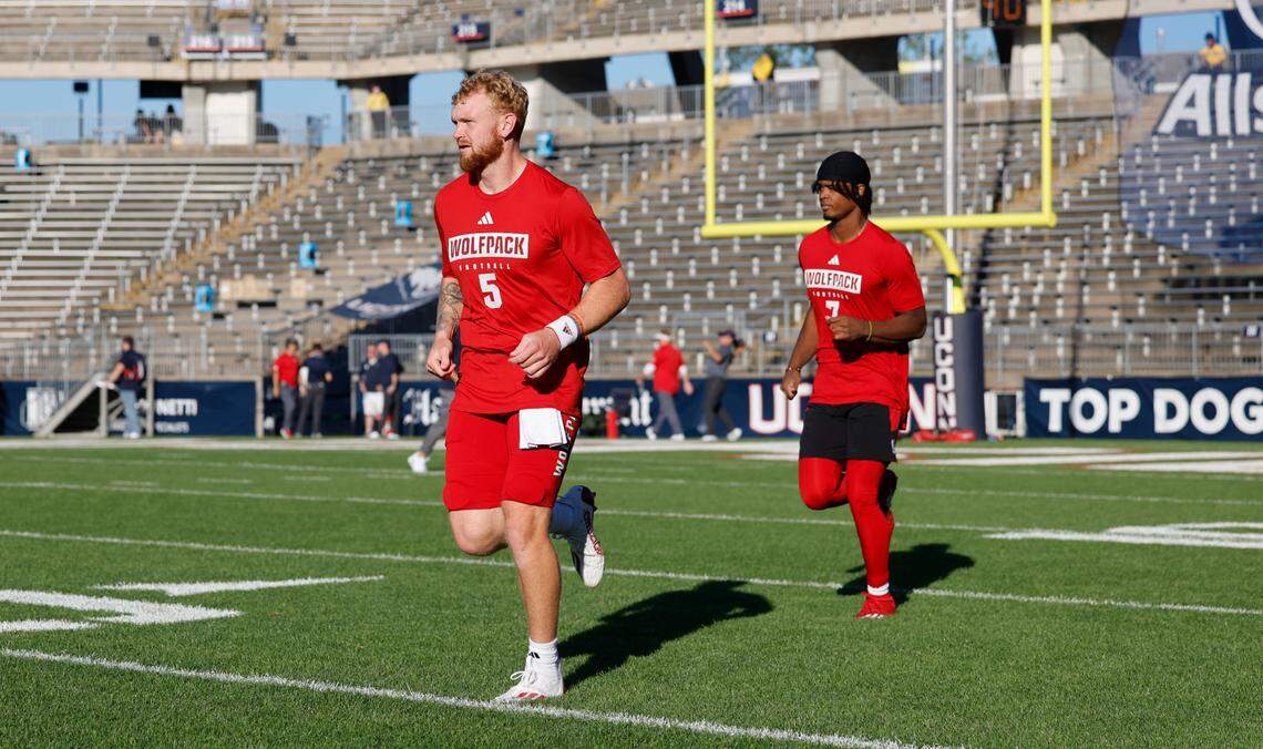 N.C. State quarterbacks Brennan Armstrong (5) and MJ Morris (7) run onto the field to warmup before the Wolfpack’s’ game against UConn at Rentschler Field in East Hartford, Conn. Thursday, August 31, 2023.
