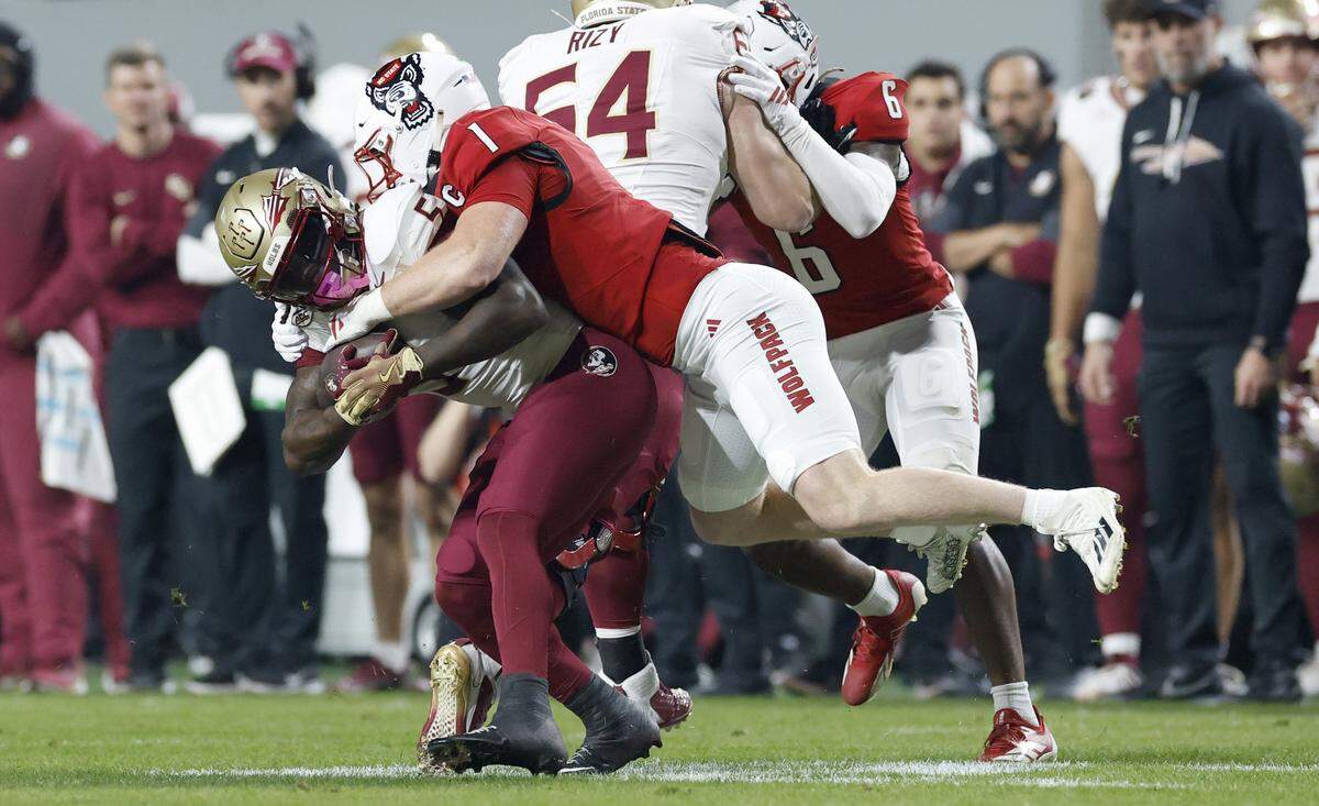 N.C. State linebacker Caden Fordham (1) tackles Florida State running back Roydell Williams (5) during the first half of N.C. State’s game against Florida State at Carter-Finley Stadium in Raleigh, N.C., Friday, Nov. 21, 2025.
