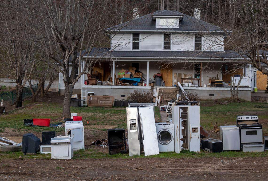Appliances from the home of Jewel Warrick and her son, James, lined up for removal nearly six moths after remnants of Hurricane Helene unleashed historic flooding. Water from the North Toe River sent several feet of water into their home.