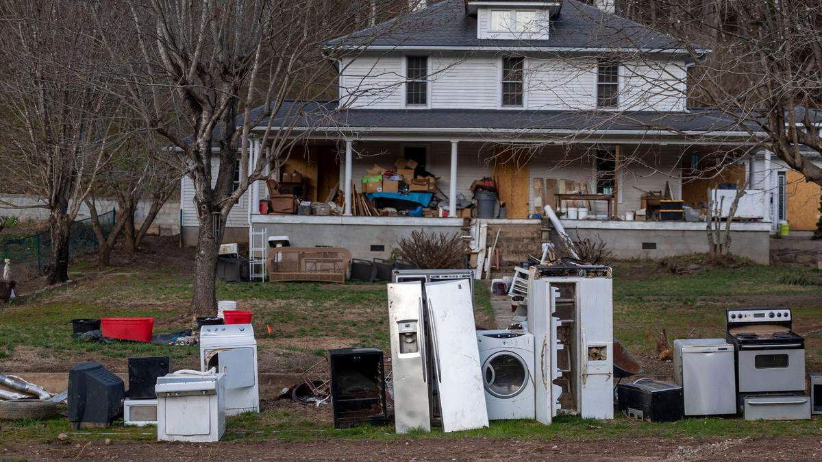 Appliances from the home of Jewel Warrick and her son James Warrick are lined up for removal in their front yard on Sunday, March 16, 2025,  nearly six moths after historic flooding of the North Toe River during Hurricane Helene sent several feet of water into their home.  