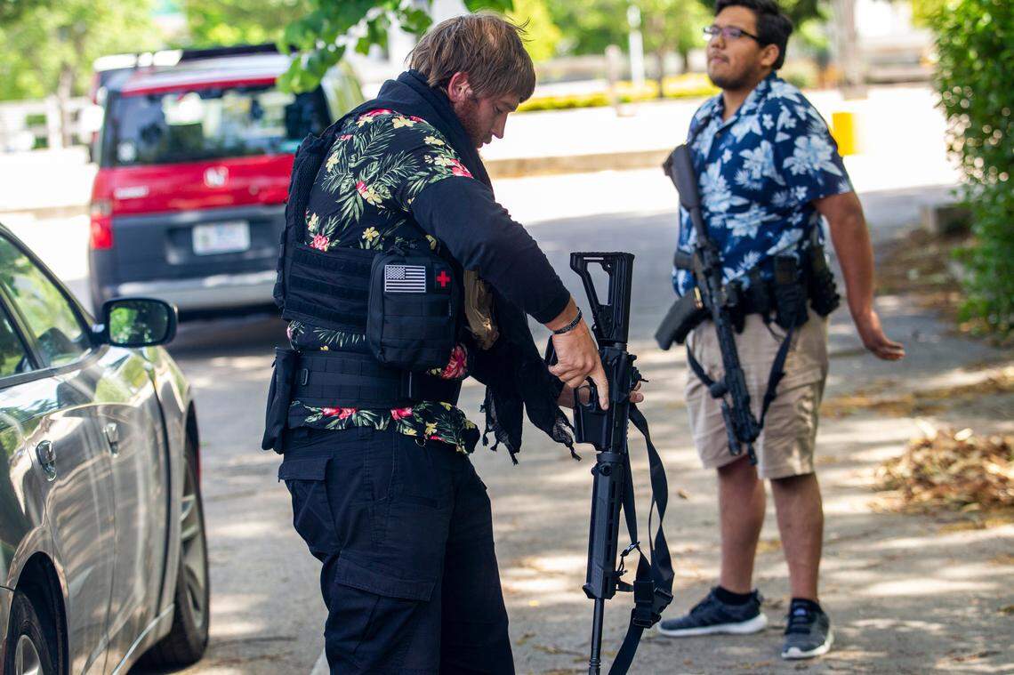 Members of a group of about a half dozen mostly armed demonstrators affiliated with the Facebook group Blue Igloo prepare to march in downtown Raleigh Saturday, May, 16, 2020.