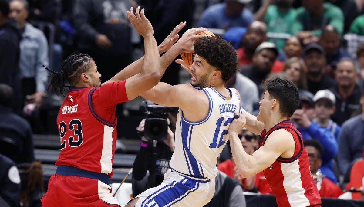Duke’s Cameron Boozer (12) is pressured by St. John's Bryce Hopkins (23) and Dylan Darling (0) during the first half of Duke’s game against St. John’s in the Sweet 16 of the NCAA Men’s Basketball East Regional at Capital One Arena in Washington, D.C., Friday, March 27, 2026.