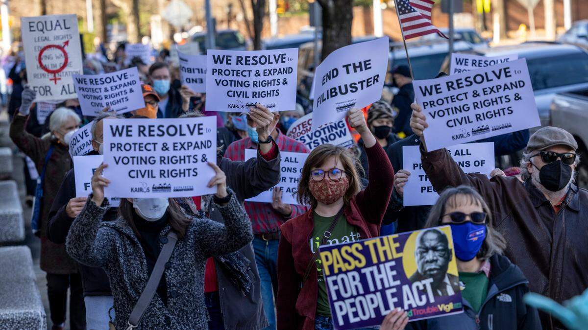 About 150 people demonstrate outside the Federal Building on New Bern Avenue in Raleigh Thursday, Jan.6 2022 on the one year anniversary of the U.S. Capitol attack. The protest organized by the North Carolina Poor People’s Campaign urged lawmakers to pass the Freedom to Vote Act and the Protecting Our Democracy Act.