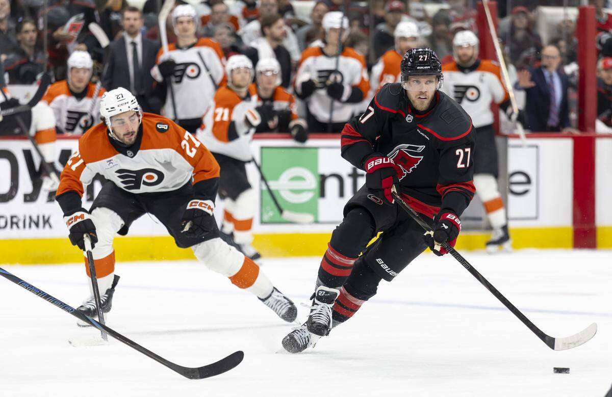 Carolina Hurricanes left wing Nikolaj Ehlers pushes the puck ahead of Philadelphia left wing Noah Cates in the first period of Game 1 on Saturday, May 2, 2026, during the second round of the Stanley Cup Playoffs at Lenovo Center in Raleigh.