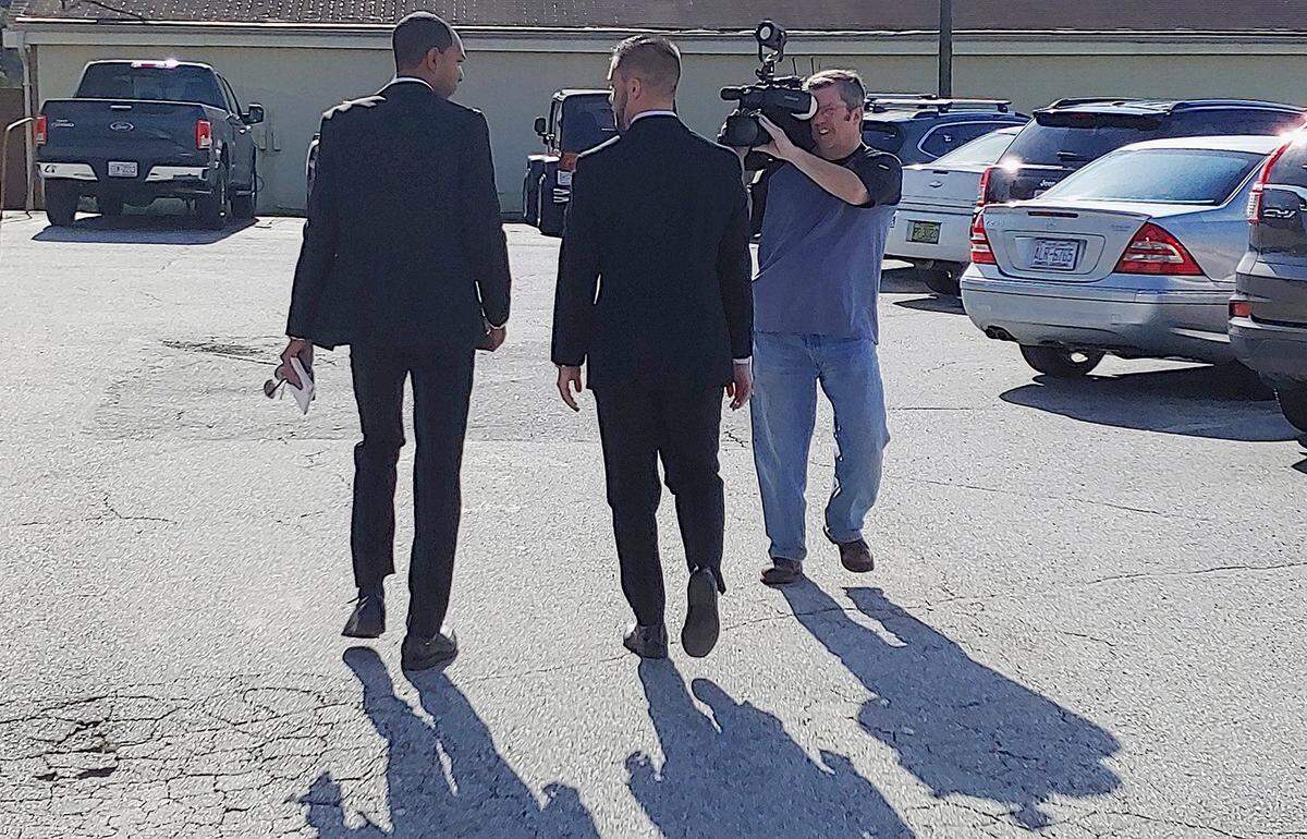 State Rep. Cody Henson, R-Transylvania, center, exits the Transylvania County Courthouse in Brevard after a first appearance on a cyberstalking charge Thursday, as WLOS reporter Justin Hinton, left, and camera operator Todd Robbins attempt to interview him.
