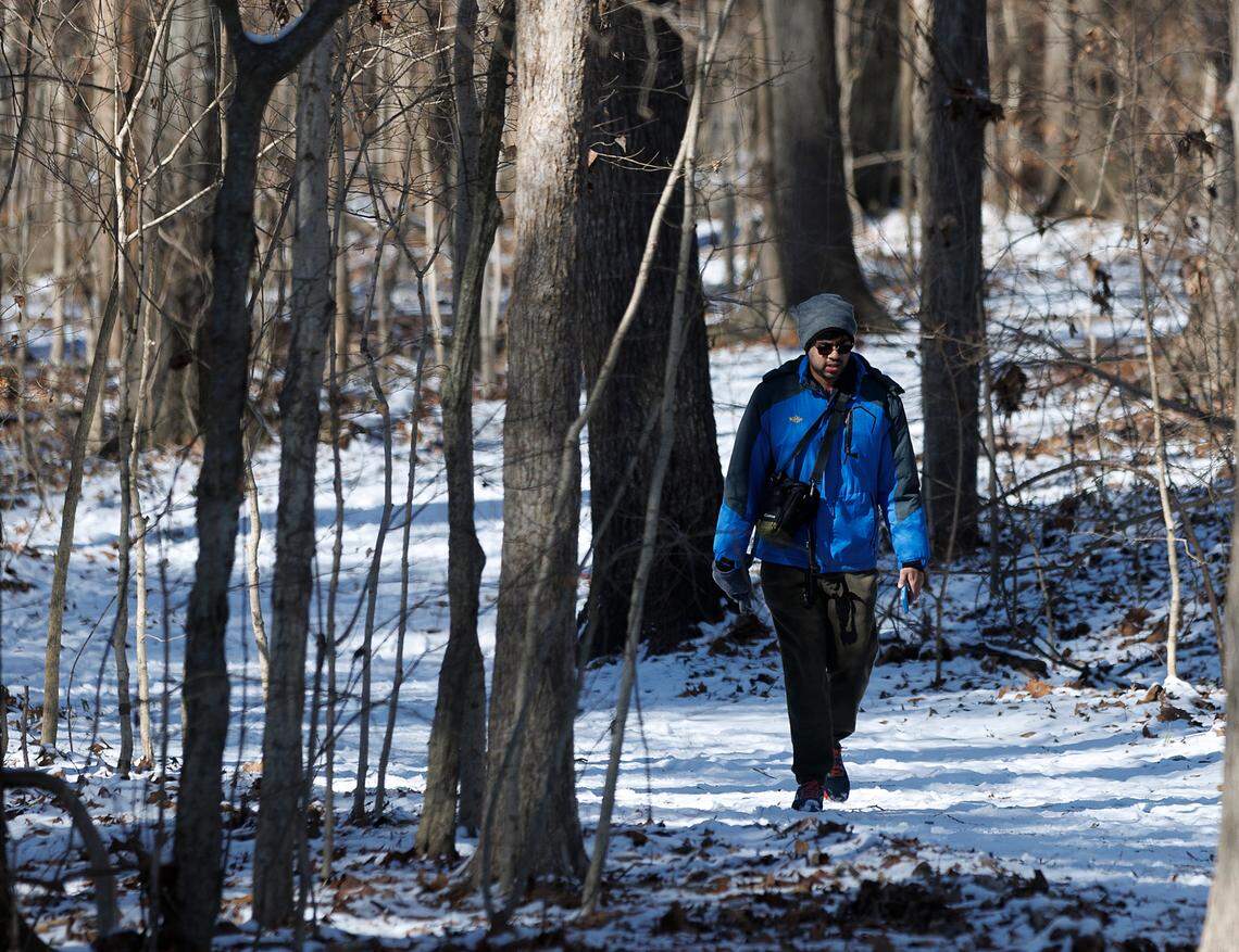 A person walks along a snow-covered trail at Bond Park on Wednesday, Jan. 22, 2025, in Cary, N.C.
