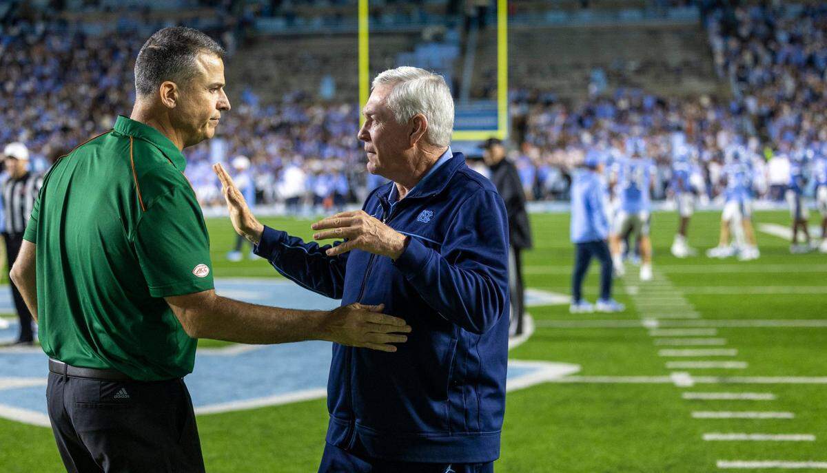 North Carolina coach Mack Brown talks with Miami coach Mario Cristobal prior to their game on Saturday, October 14, 2023 at Kenan Stadium in Chapel Hill, N.C.
