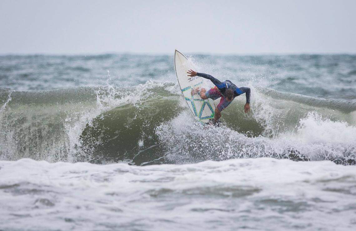 A surfer rides a wave in big swells brought on by Tropical Storm Isaias near Bogue Inlet Pier in Emerald Isle, N.C. on Monday evening, Aug. 3, 2020.
