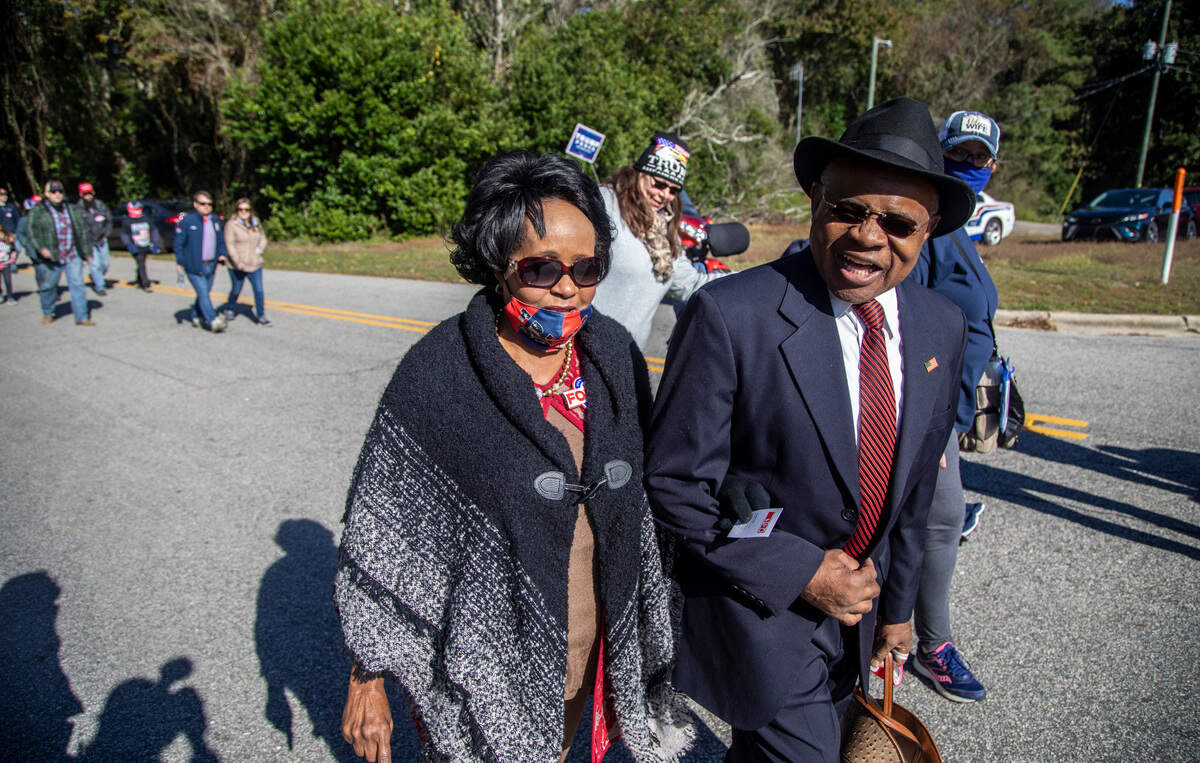 President Donald Trump supporters, Larry and Gloria King of Rutherfordton, make their way to a campaign rally, Monday, Nov. 2, 2020 at Fayetteville Regional Airport.