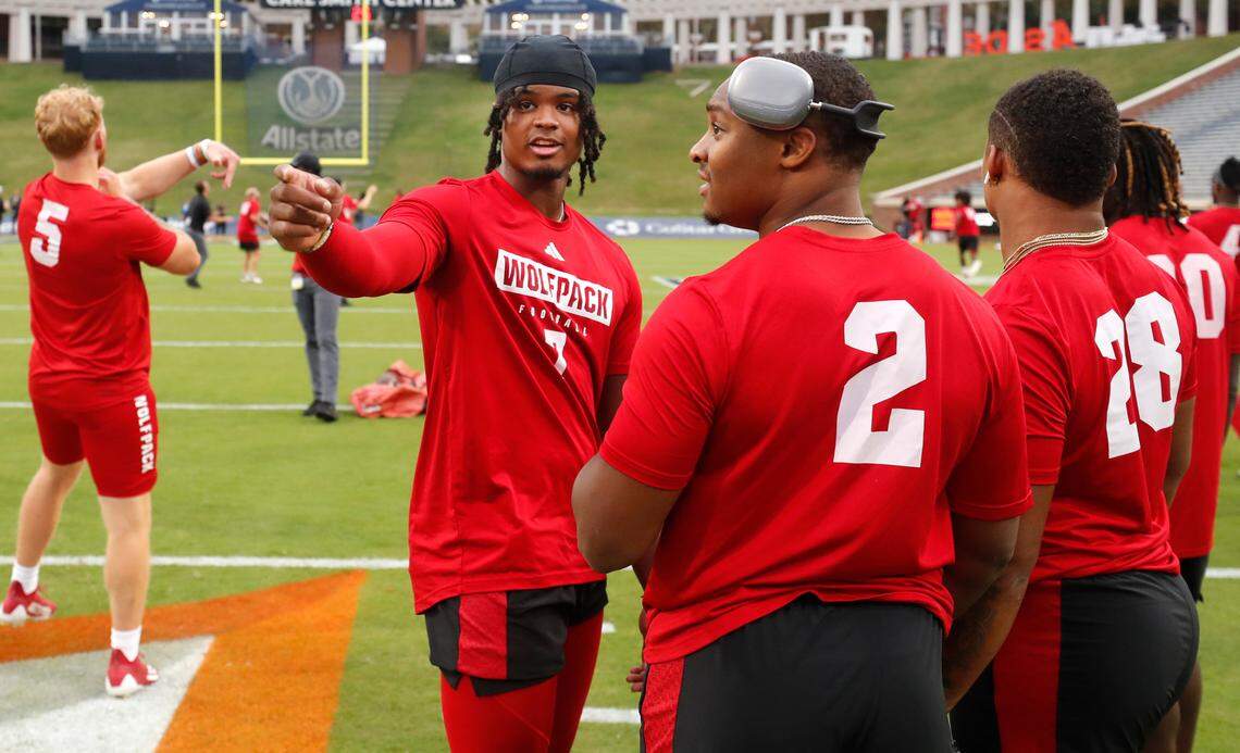 N.C. State quarterback MJ Morris (7) talks with running back Michael Allen (2) during warmups before N.C. State’s game against Virginia at Scott Stadium in Charlottesville, Va., Friday, Sept. 22, 2023.